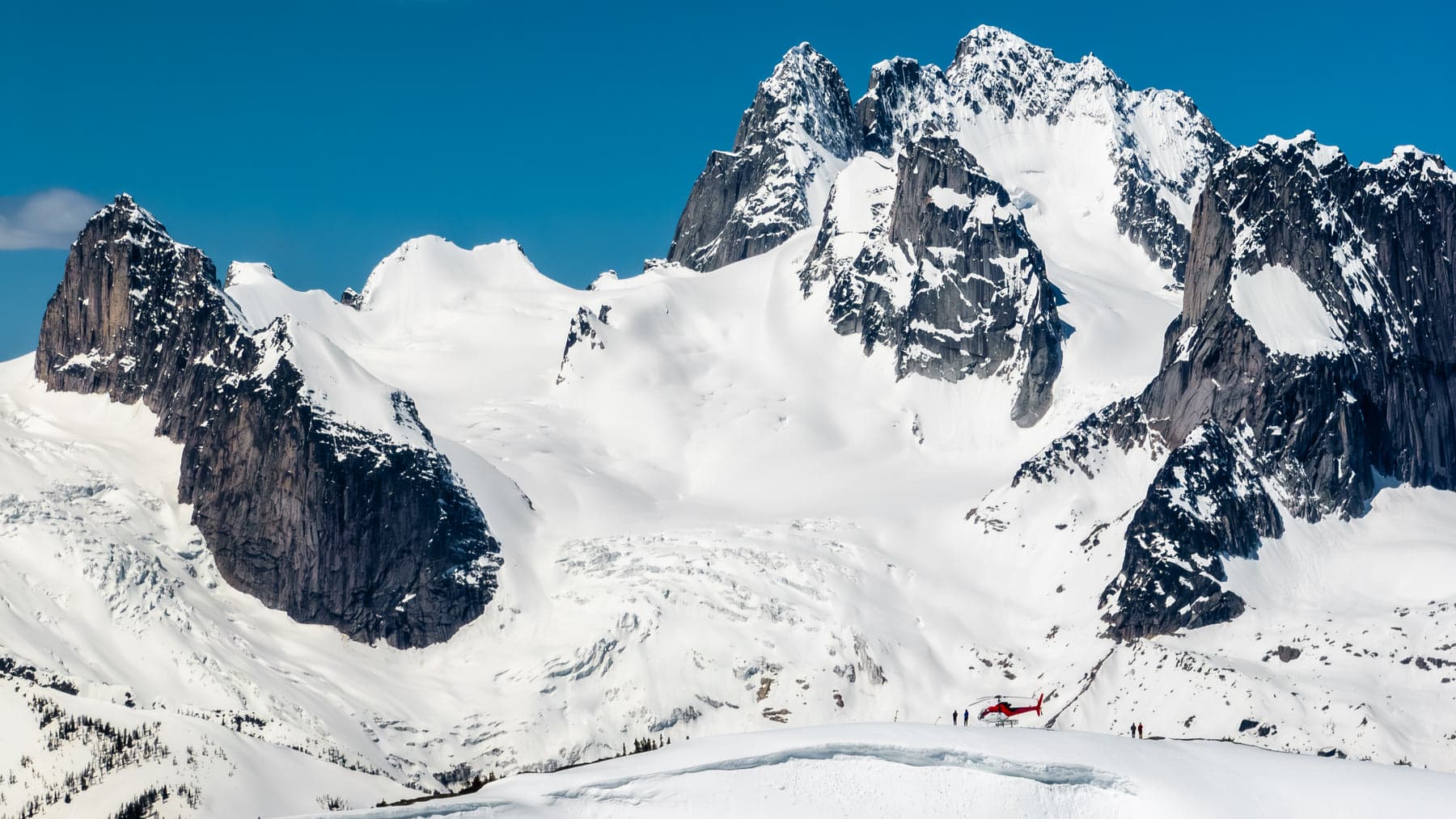 A Glacier Helicopters aircraft landed amid snow-capped alpine peaks